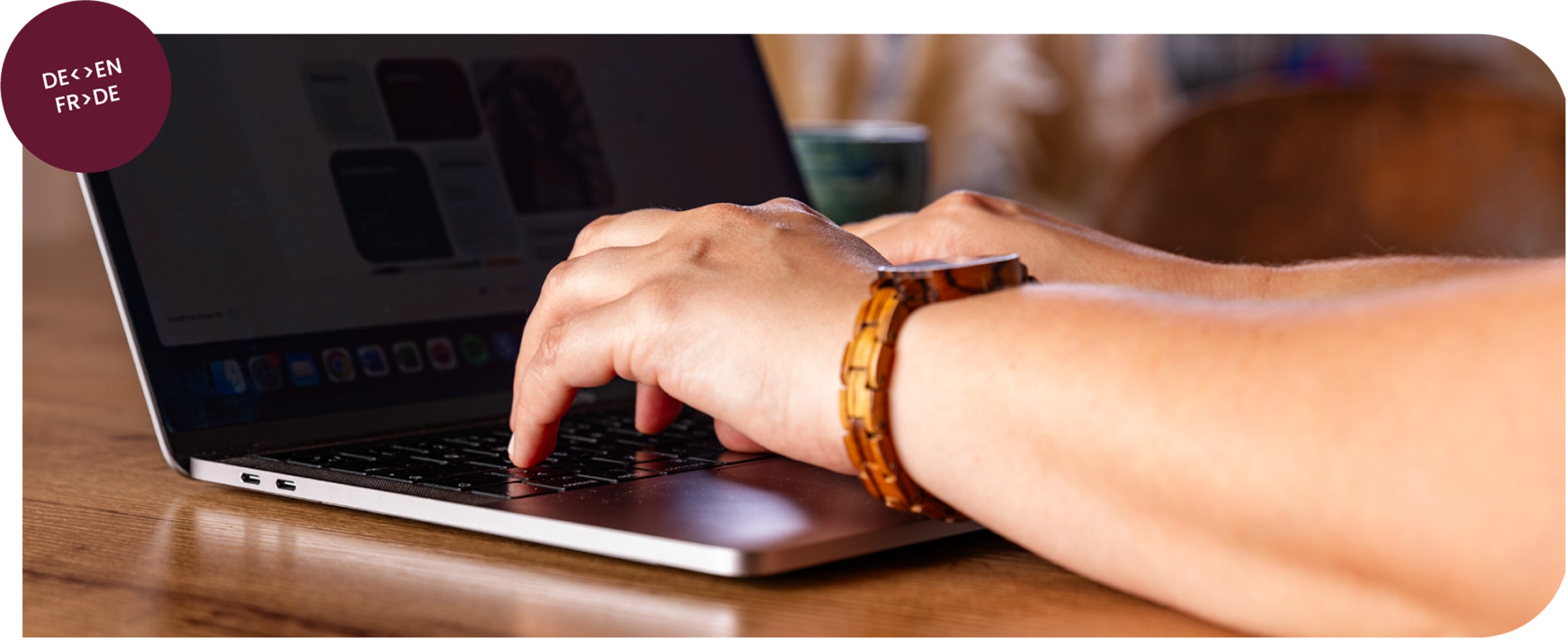 Image showing a person's arms whily typing something on a laptop.