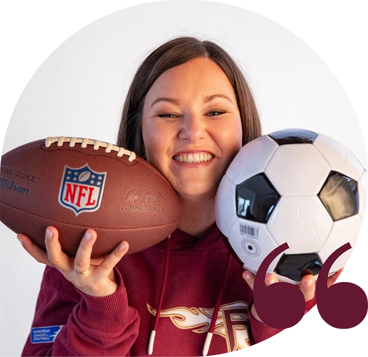 Birgit Spalt-Zoidl strahlt in die Kamera und hält links und rechts von ihrem Gesicht einen Football und einen Fußball.